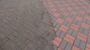 Brick paving transition from weathered gray bricks on left to reddish-brown bricks on right, showing texture and color contrast