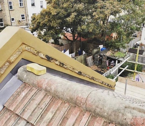 Roofing installation with yellow insulation material and rolled underlayment on residential building