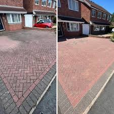 Before and after comparison of driveway cleaning, showing darker dirty paving on left and lighter cleaned paving on right
